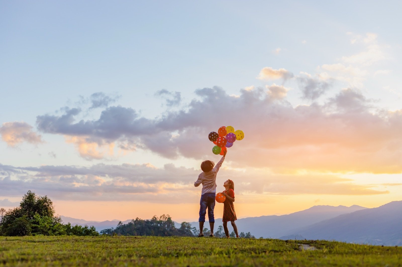 Bambini al tramonto con palloncini